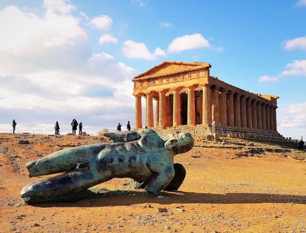 Temple of Concordia and Fallen Icarus sculpture in Agrigento, Sicily on a sunny day.