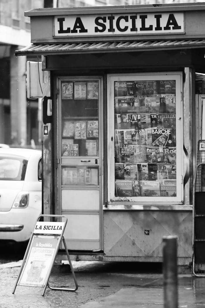 A black and white photo of a Sicilian newsstand in Catania showcases local culture and daily life.